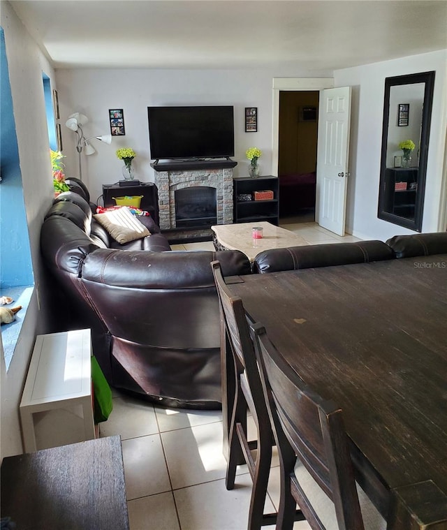 living room featuring a fireplace and light tile patterned floors