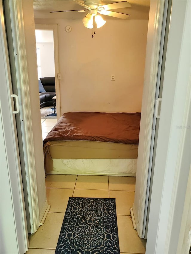 bedroom with ceiling fan and light tile patterned floors