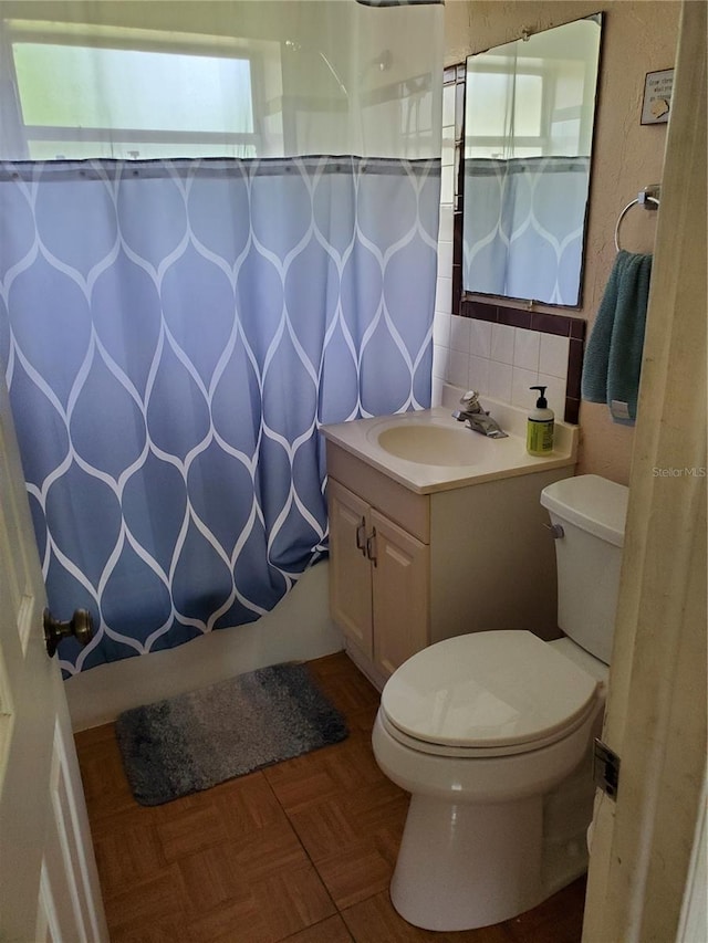 bathroom featuring parquet floors, vanity, and toilet