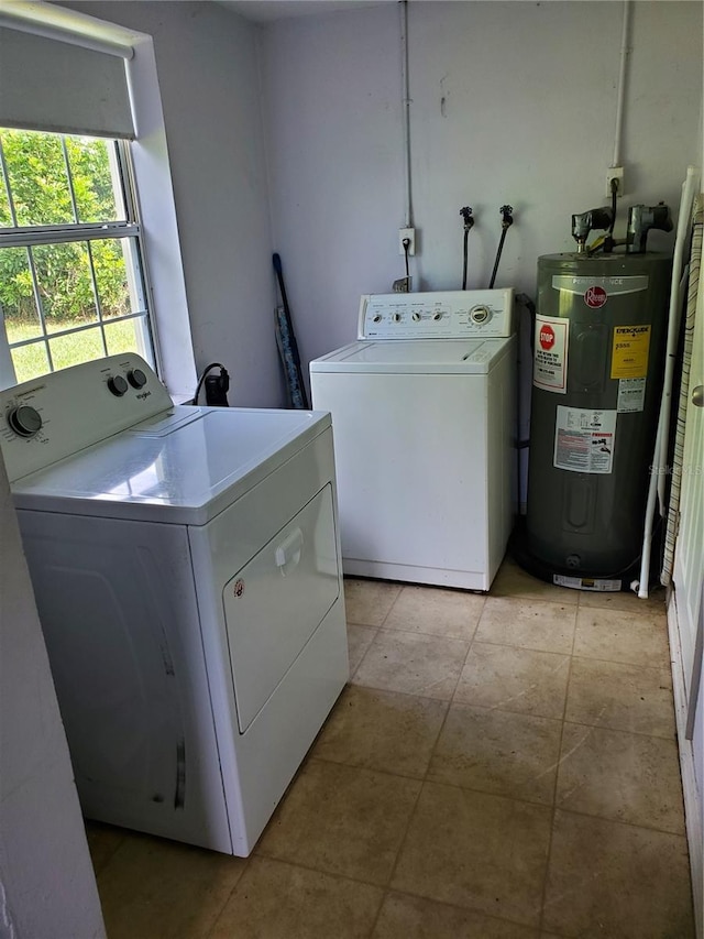 laundry room featuring water heater, washer and dryer, and light tile patterned floors