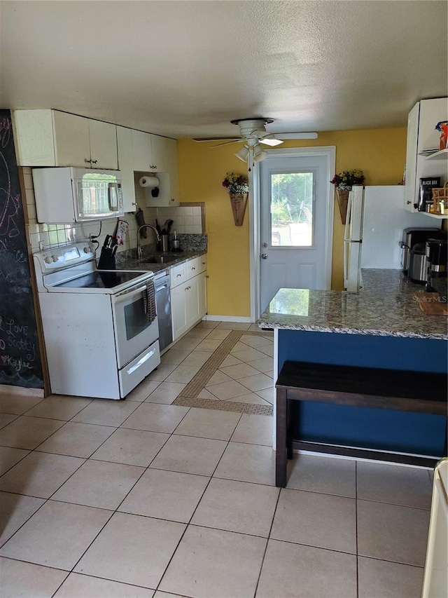 kitchen with ceiling fan, white cabinets, decorative backsplash, white appliances, and light tile patterned floors