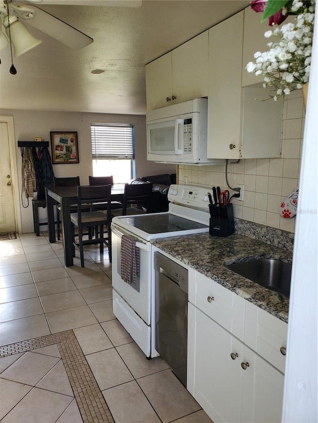 kitchen featuring light tile patterned flooring, white cabinetry, tasteful backsplash, ceiling fan, and white appliances