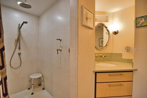 bathroom featuring vanity and a tile shower