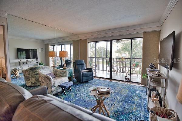 living room featuring a textured ceiling and ornamental molding