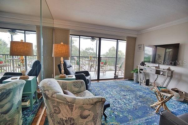 living room featuring a textured ceiling and ornamental molding