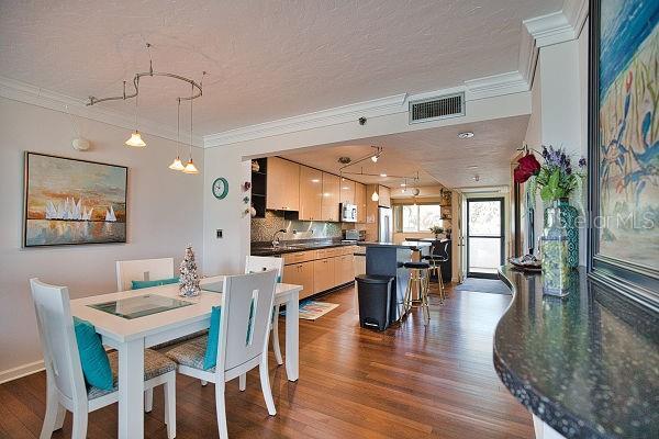 dining room featuring dark hardwood / wood-style floors, a textured ceiling, sink, and ornamental molding