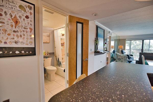 hallway with a textured ceiling and light tile patterned floors