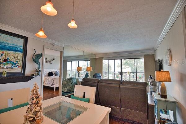 living room featuring a textured ceiling, hardwood / wood-style flooring, and ornamental molding