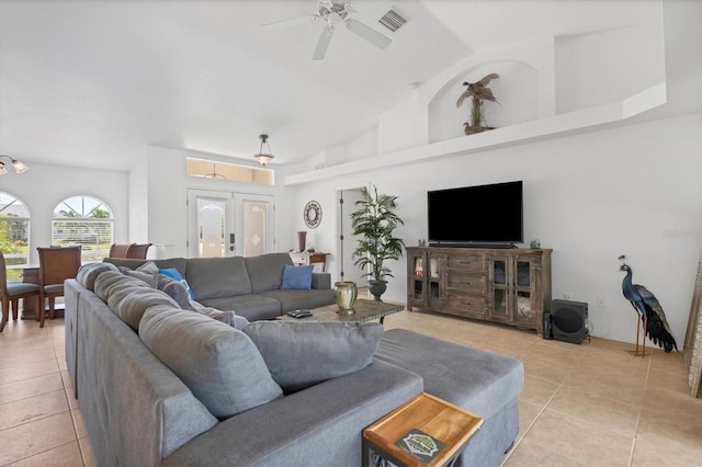 tiled living room with ceiling fan, high vaulted ceiling, and french doors