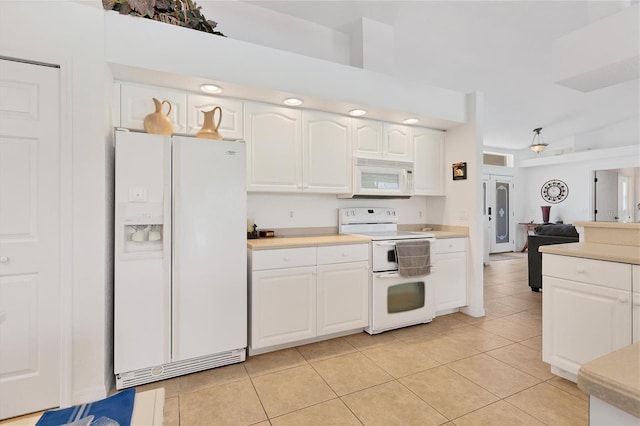 kitchen with light tile patterned floors, white cabinets, and white appliances