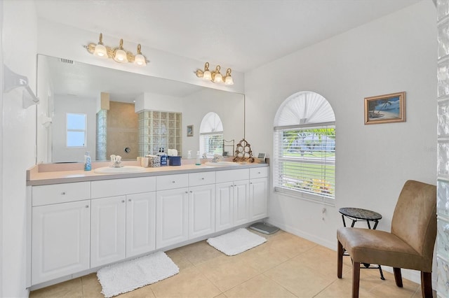 bathroom with walk in shower, vanity, and tile patterned floors