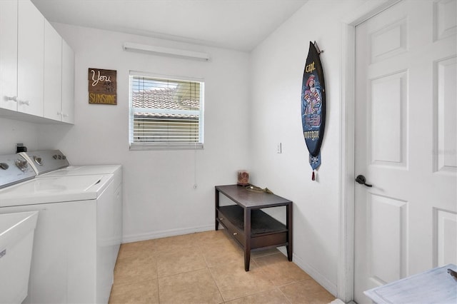 washroom with cabinets, light tile patterned flooring, separate washer and dryer, and sink