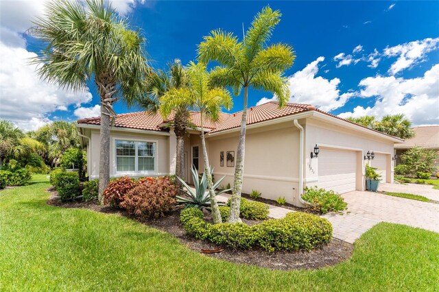 mediterranean / spanish-style house featuring a front yard and a garage