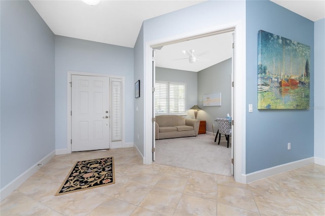 carpeted foyer entrance with ceiling fan