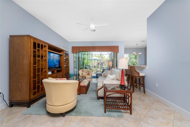 living room with ceiling fan with notable chandelier and light tile patterned floors