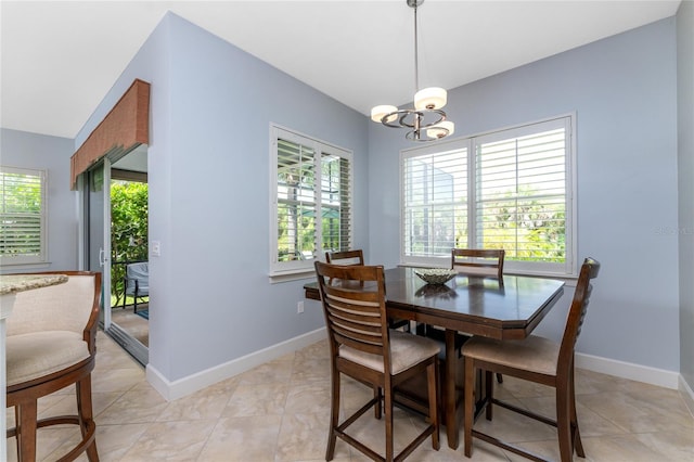 dining room with light tile patterned floors, a healthy amount of sunlight, and a chandelier