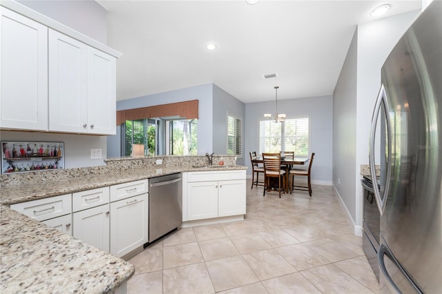 kitchen featuring a wealth of natural light, stainless steel appliances, sink, and white cabinetry