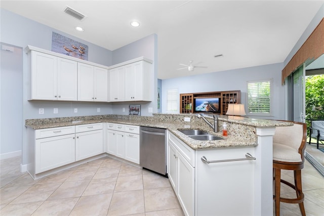 kitchen featuring kitchen peninsula, sink, ceiling fan, a breakfast bar, and stainless steel dishwasher