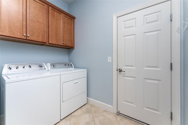 washroom featuring cabinets, washer and clothes dryer, and light tile patterned flooring