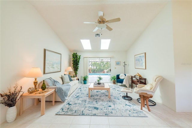 living room featuring ceiling fan, lofted ceiling with skylight, and light tile patterned floors