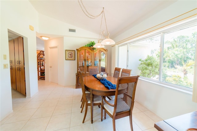 tiled dining area featuring vaulted ceiling