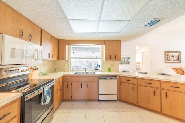 kitchen featuring light tile patterned flooring, white appliances, and sink