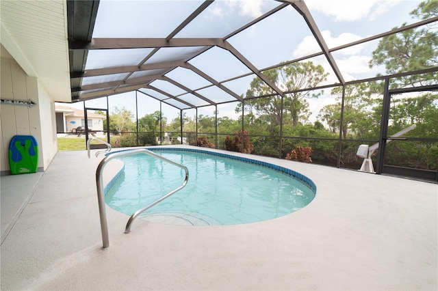 view of swimming pool with glass enclosure and a patio area