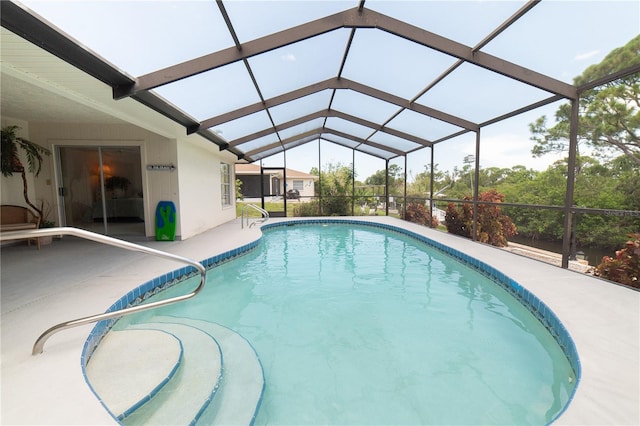 view of pool with glass enclosure and a patio area