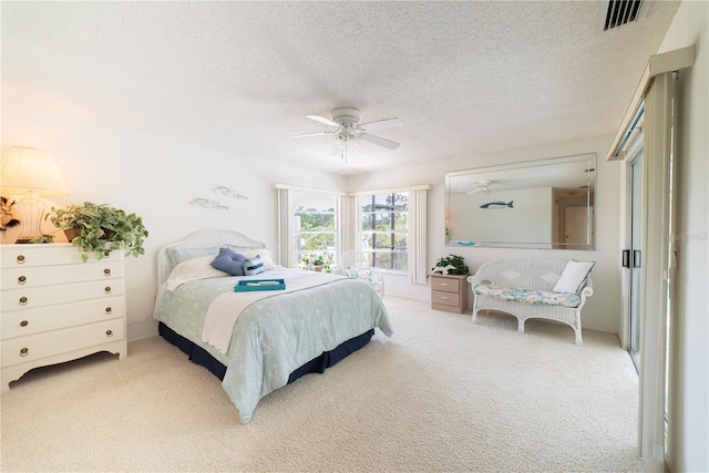 bedroom featuring carpet, a textured ceiling, and ceiling fan