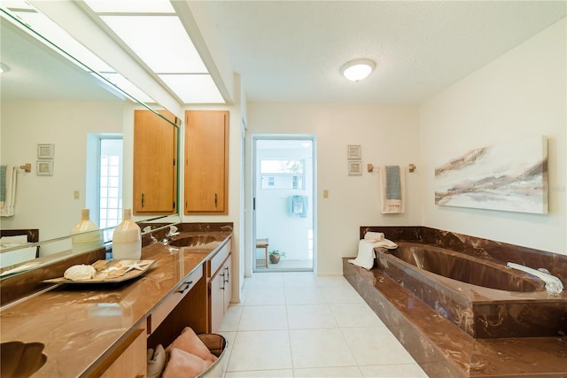 bathroom featuring vanity, tiled tub, tile patterned floors, and a textured ceiling