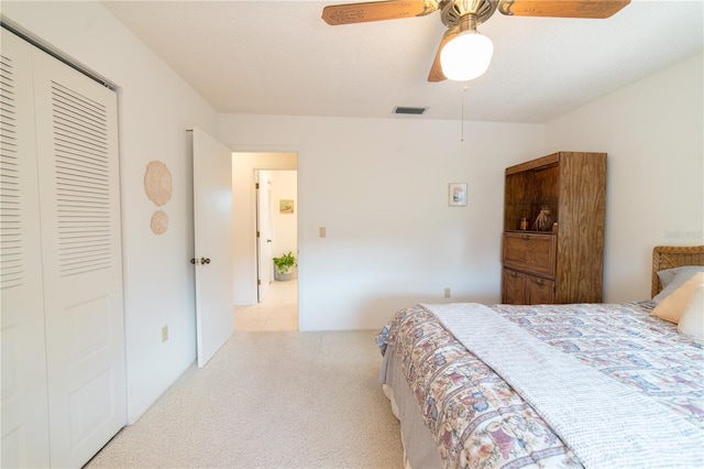 bedroom featuring ceiling fan, light carpet, and a closet