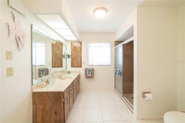 bathroom with tile patterned flooring, vanity, an enclosed shower, toilet, and a textured ceiling