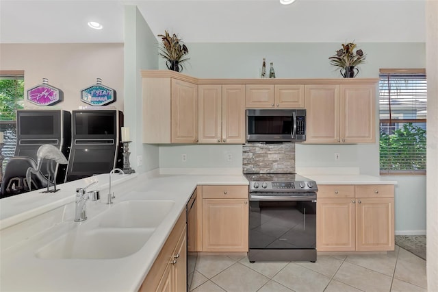 kitchen featuring light tile patterned floors, stainless steel appliances, light brown cabinetry, and sink