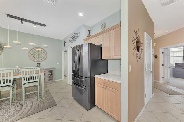 kitchen featuring stainless steel refrigerator with ice dispenser, light brown cabinets, decorative light fixtures, light tile patterned flooring, and track lighting