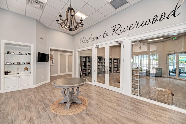 interior space with built in features, an inviting chandelier, and a towering ceiling