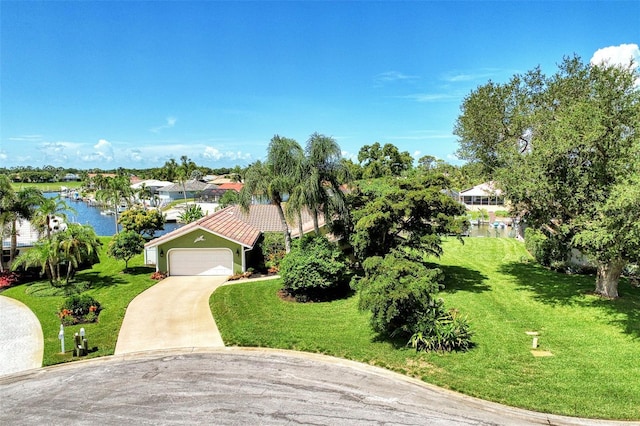 view of front of home with a front yard, a garage, and a water view