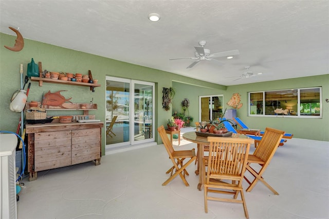 dining space featuring ceiling fan and a textured ceiling