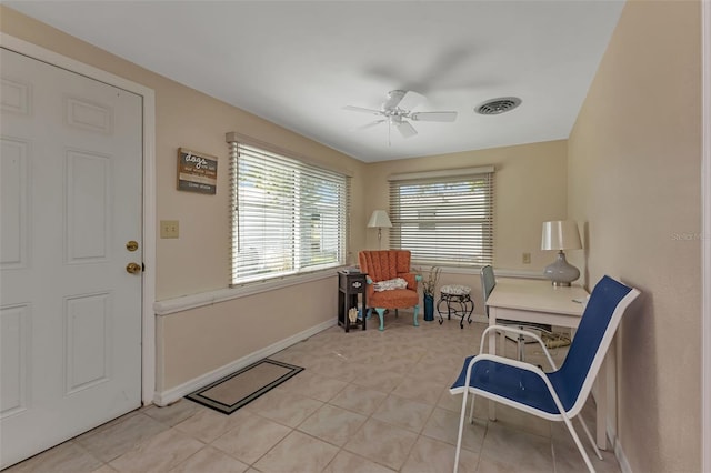 living area featuring light tile patterned floors and ceiling fan