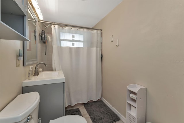 bathroom with walk in shower, vanity, and toilet