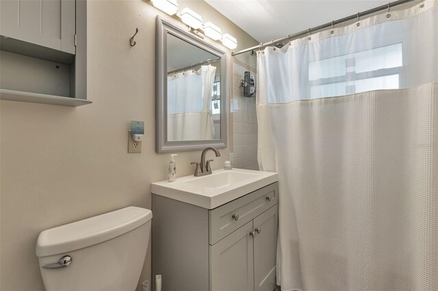 bathroom featuring vanity, toilet, and a shower with shower curtain