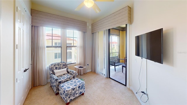 sitting room with light colored carpet and ceiling fan