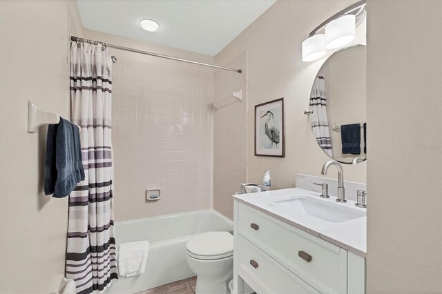 full bathroom featuring vanity, a textured ceiling, toilet, and shower / bathtub combination with curtain