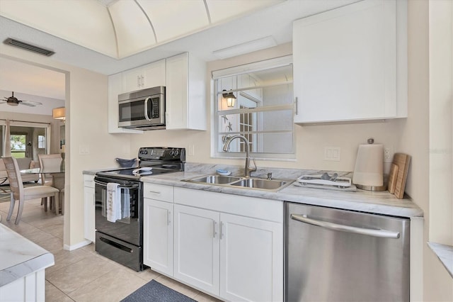 kitchen featuring light tile patterned flooring, sink, ceiling fan, stainless steel appliances, and white cabinets