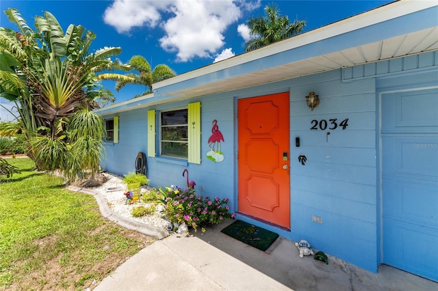 property entrance with a lawn