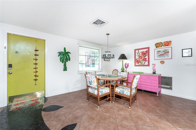 tiled dining room with an inviting chandelier