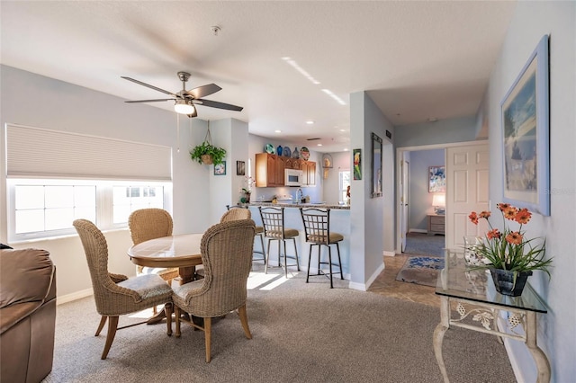 carpeted dining area featuring ceiling fan