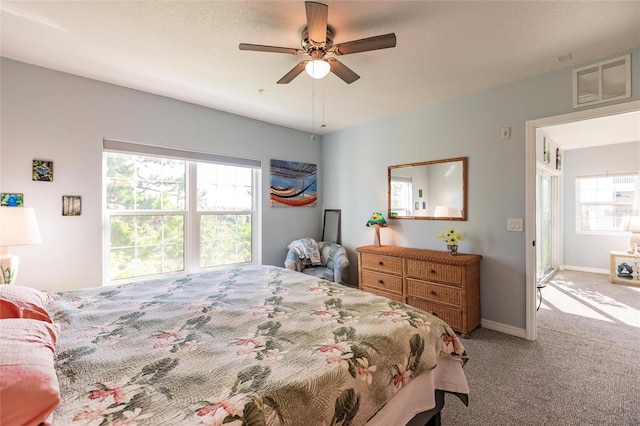 carpeted bedroom with multiple windows and ceiling fan