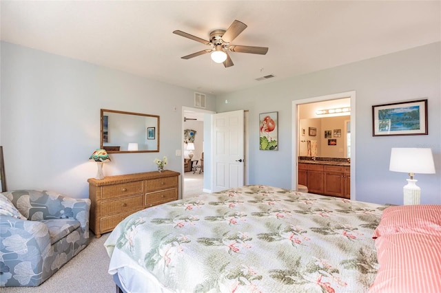 bedroom featuring light carpet, connected bathroom, and ceiling fan