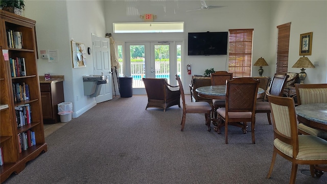 dining room featuring a high ceiling, carpet flooring, and french doors