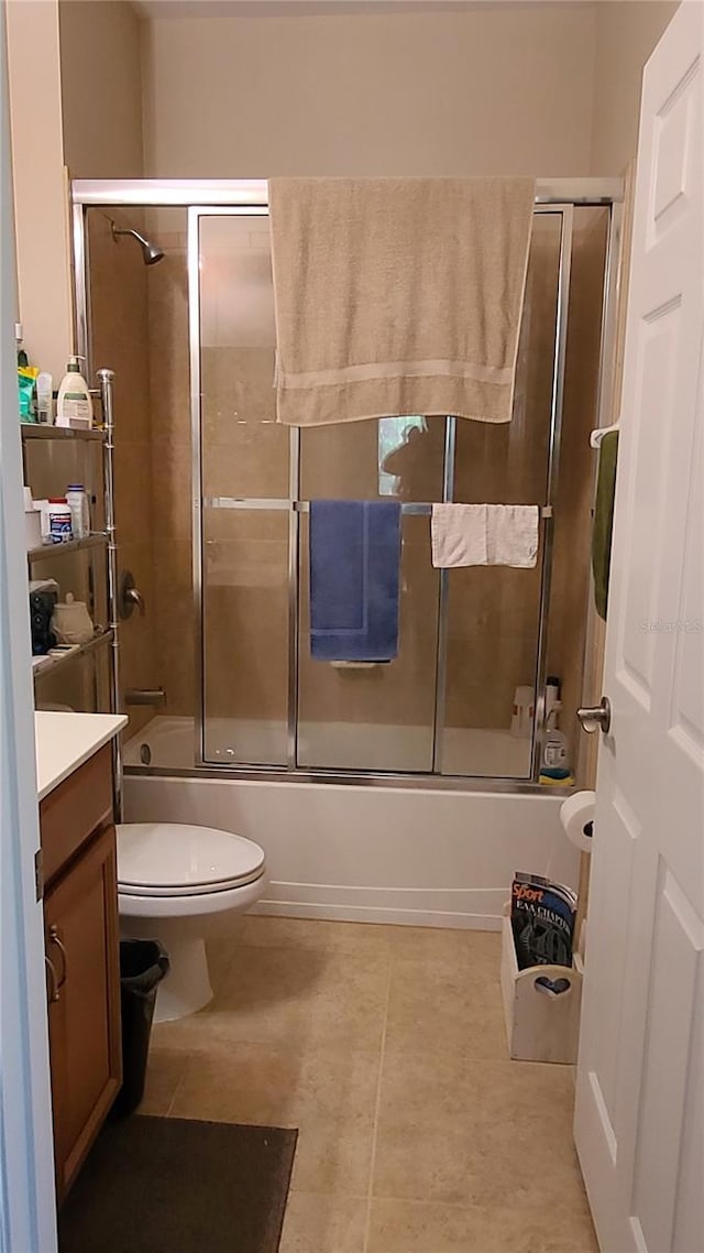 full bathroom with vanity, tile patterned floors, toilet, and combined bath / shower with glass door